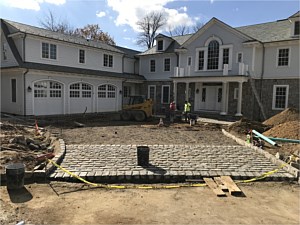 hamptons style driveway with belgium block cobblestone apron and inlays stasi brothers waterfront natural stone veneer